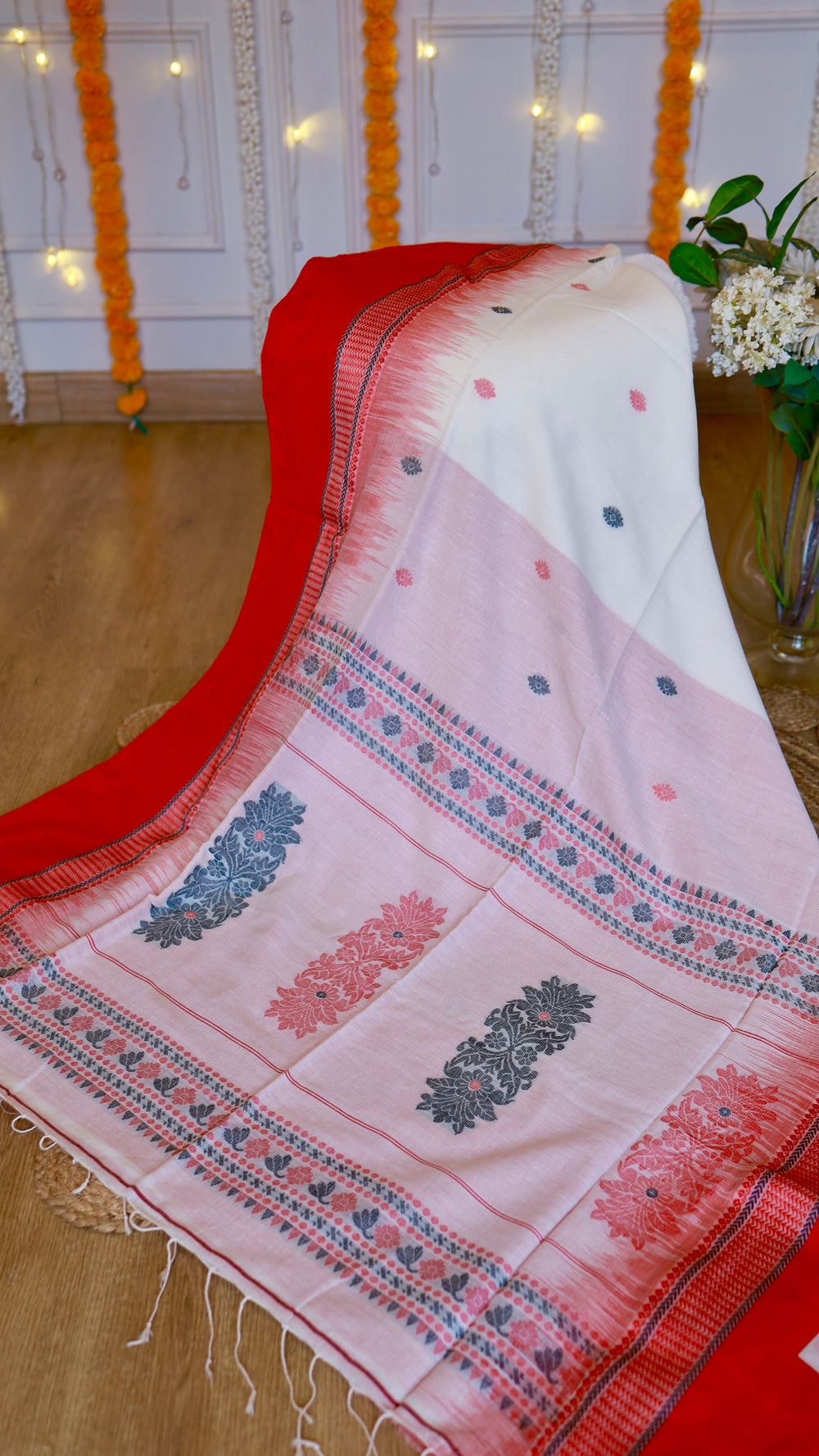 Detailed view of the intricate pallu woven motifs and hand-tied white fringes on off-white and red cotton Bomkai saree