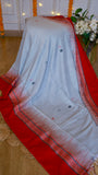 Off-white cotton Bomkai saree draped with a vibrant crimson red temple border and small woven extra-weft floral sprigs across the body.