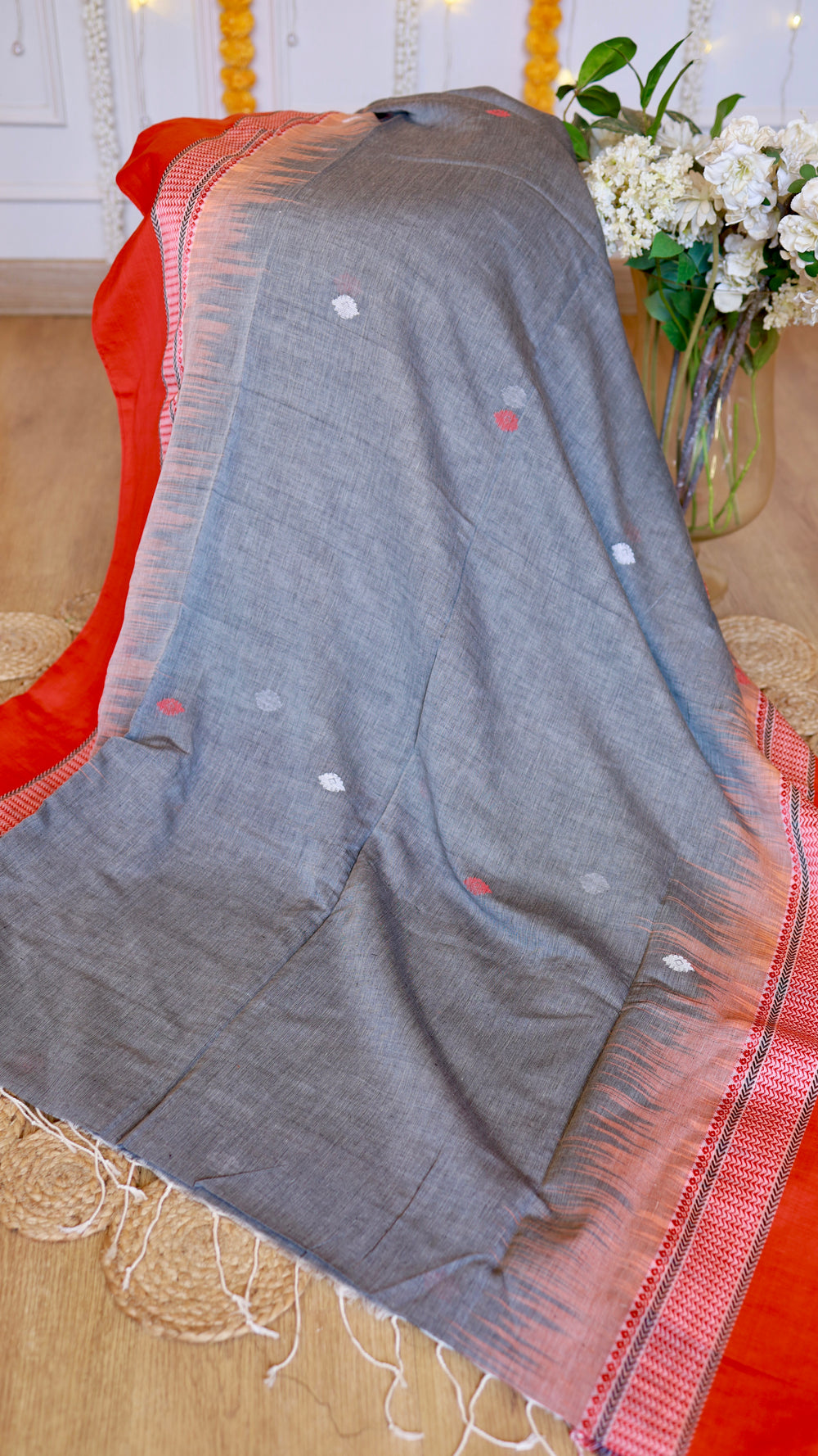 Draped grey cotton Bomkai saree with red contrast border and traditional extra-weft pallu design
