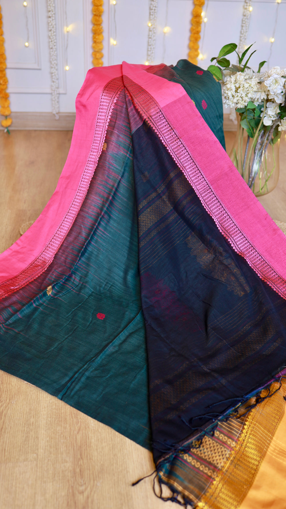 Close-up of Peacock Green Cotton Bomkai Saree showing delicate rani pink woven border and deep navy pleats.