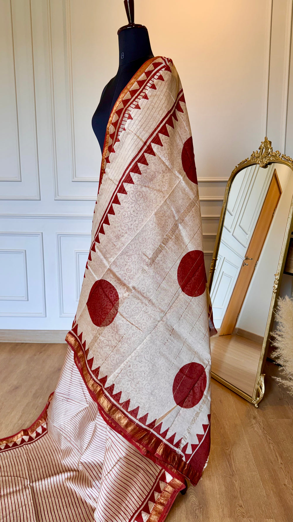Close-up of Maheshwari Silk Saree fabric showing the intricate gold zari border and geometric triangle patterns.