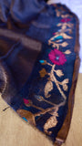 Close-up of floral vine meenakari border on midnight blue pure silk linen saree showing intricate gold and magenta weaving.