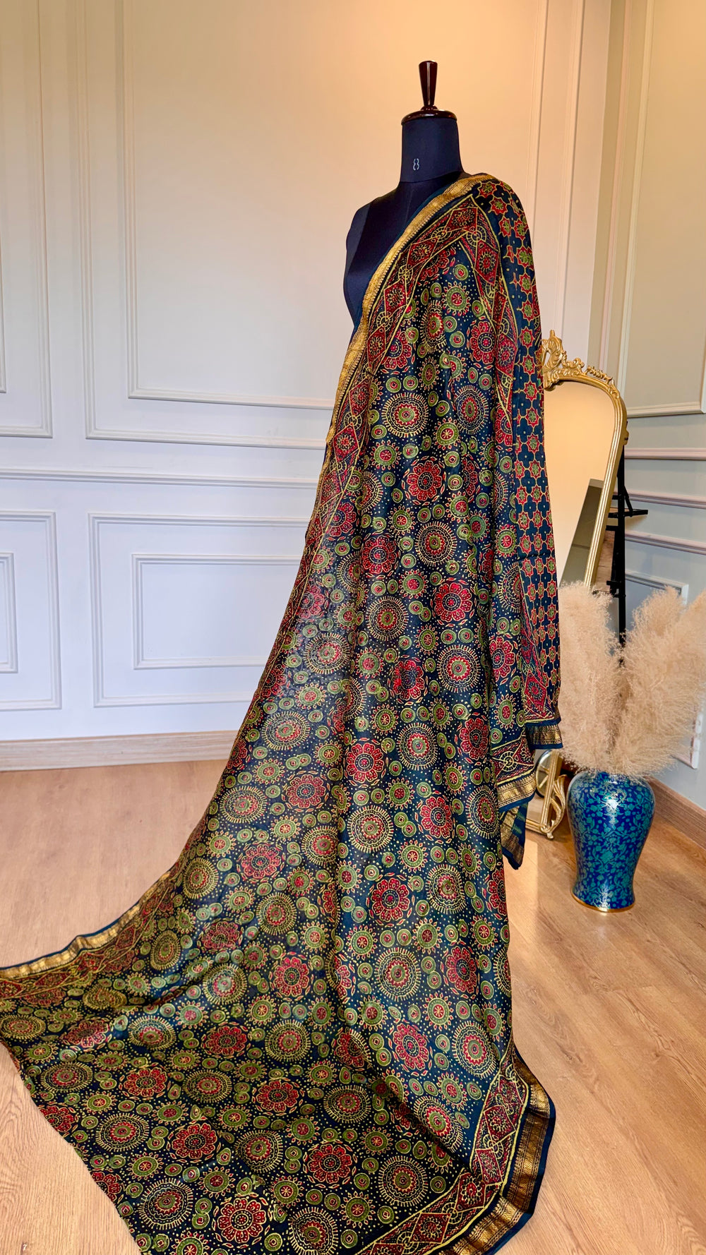 Close-up of Maheshwari saree gold zari border and intricate geometric hand-block print details on silk-cotton fabric.
