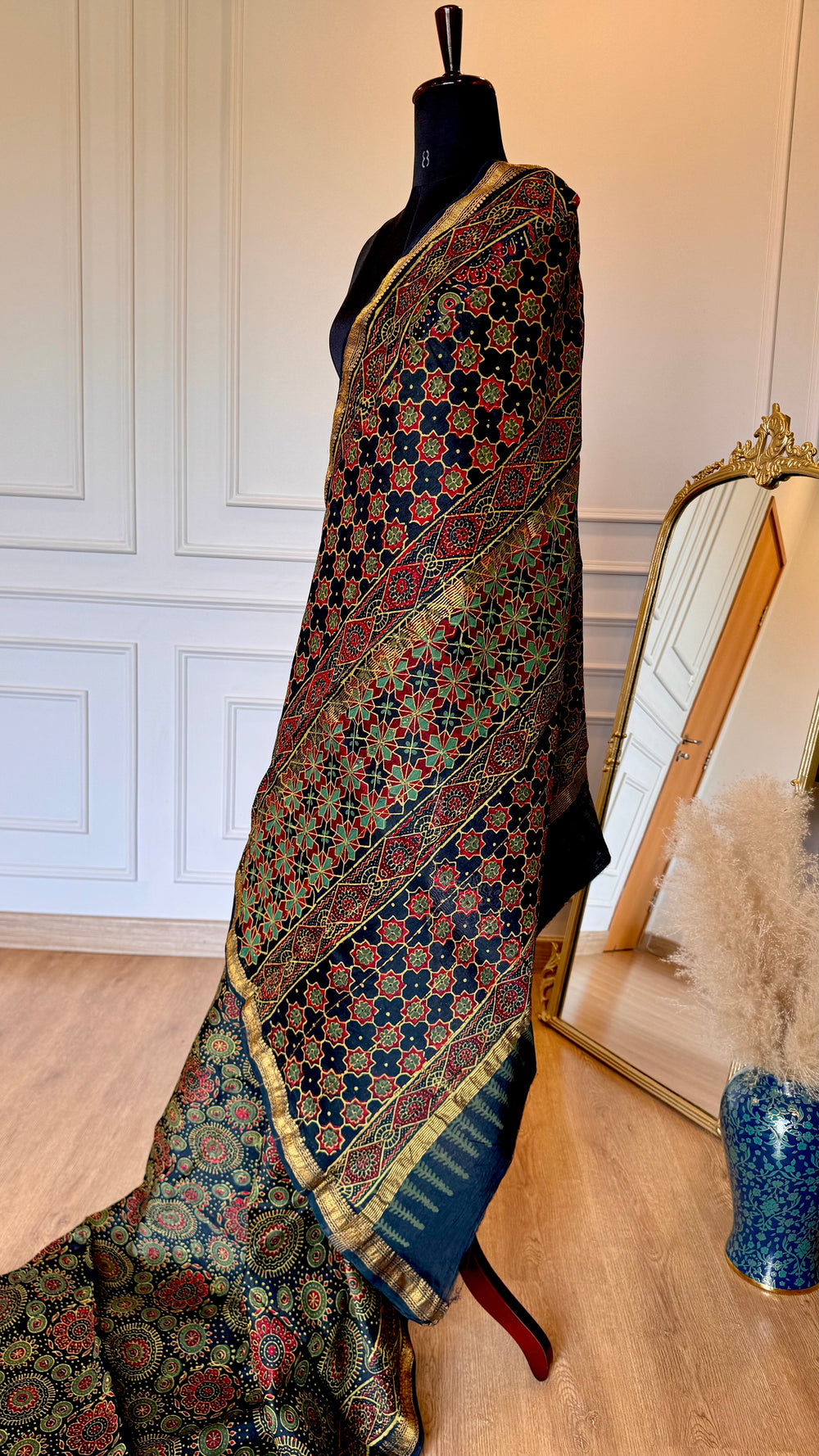Full drape of teal and rust Maheshwari saree on a mannequin showing the elegant fall and pleats.
