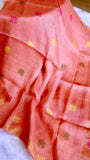 Pleated fold view of peach coral pure silk linen saree with intricate yellow and pink handloom motifs