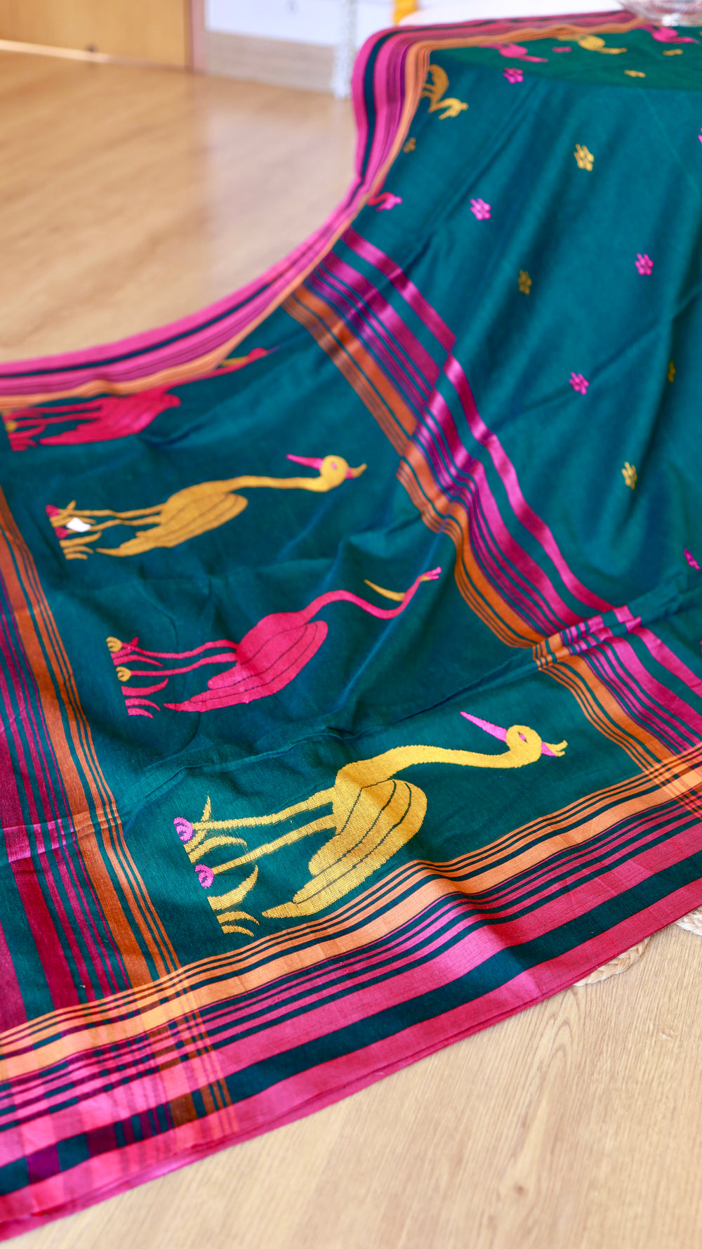 Extended drape angle of Titafu bottle green Khadi saree displaying the contrast striped pallu and running blouse section.