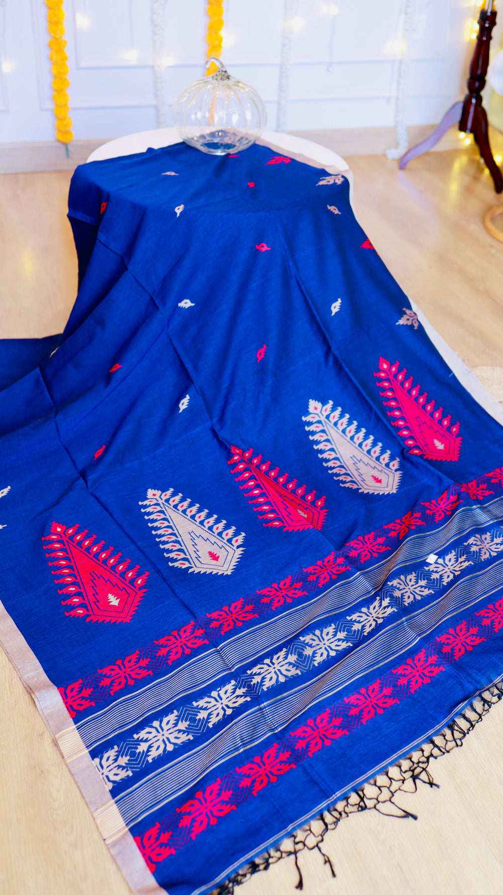 Full drape view of royal blue handwoven khadi cotton saree featuring traditional red and silver motifs.