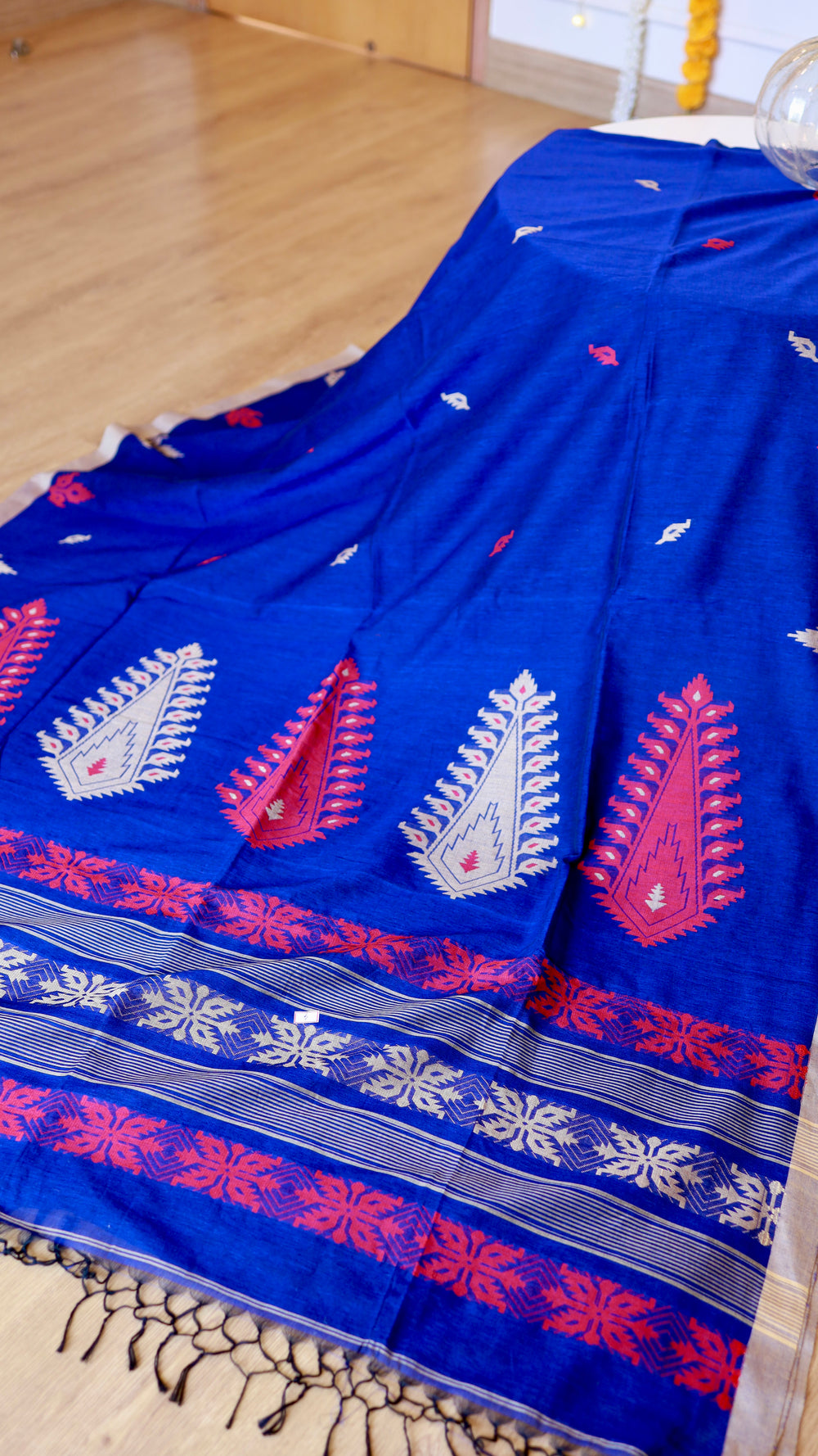 Royal blue handwoven khadi cotton saree displayed with pallu details and hand-knotted fringe tassels.