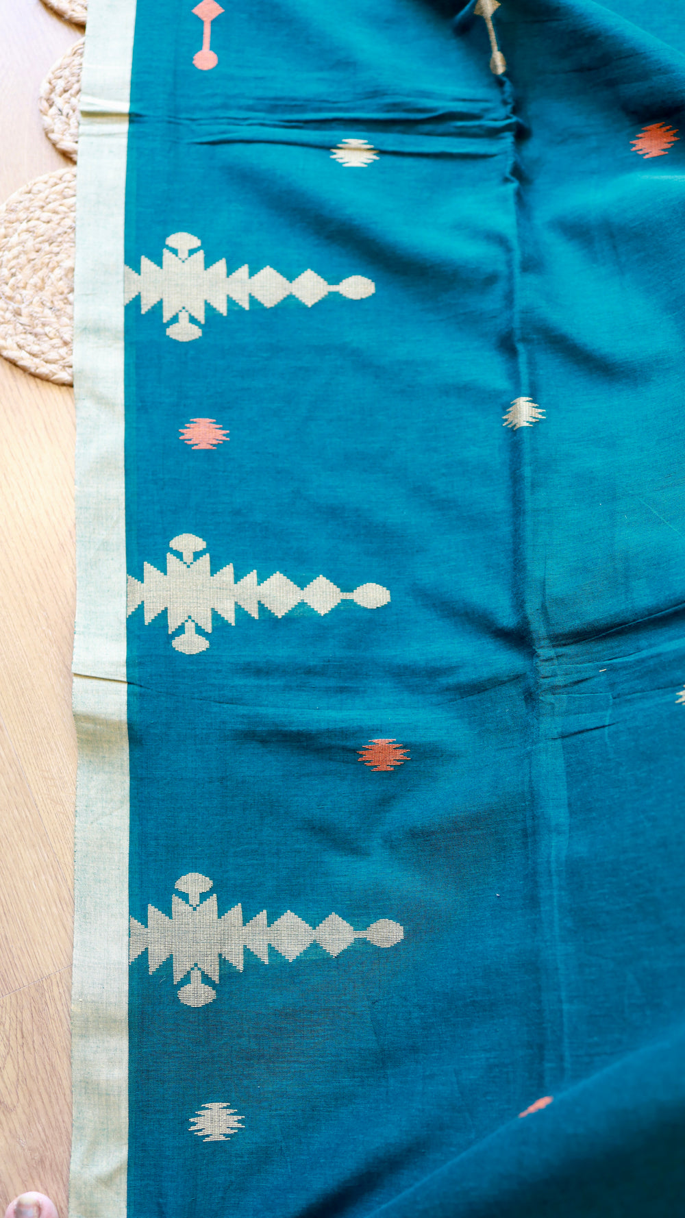 Side border close-up of Peacock Teal Khadi Cotton Saree featuring off-white selvedge and hand-loomed coral and silver tribal motifs.