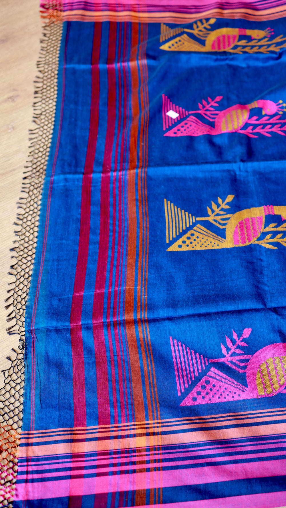 Close-up of Royal Blue Khadi Cotton Saree pallu showing woven peacock motifs in pink and gold with fringe detailing.