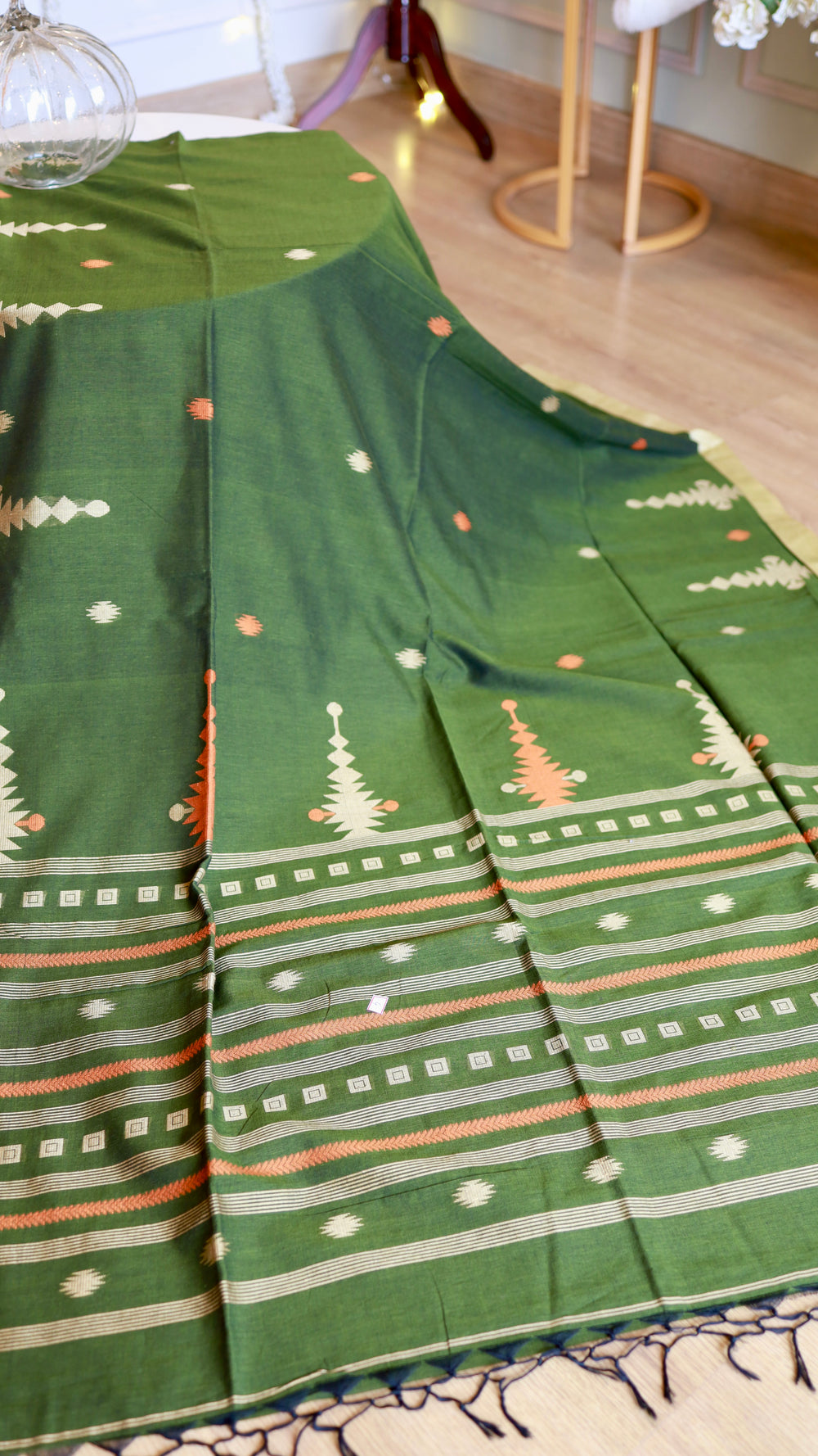 Direct view of the wide woven border on a green handwoven khadi cotton saree detailing geometric square borders and temple motifs.