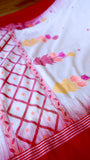 Detailed shot of the intricate red geometric lattice jaal and leaf border weave on the handwoven off-white khadi saree.