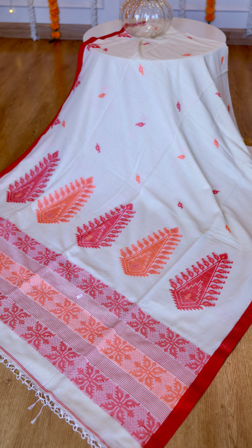 High-angle overview of Off White Khadi Cotton Saree featuring red extra-weft paisley pallu work and red woven border.
