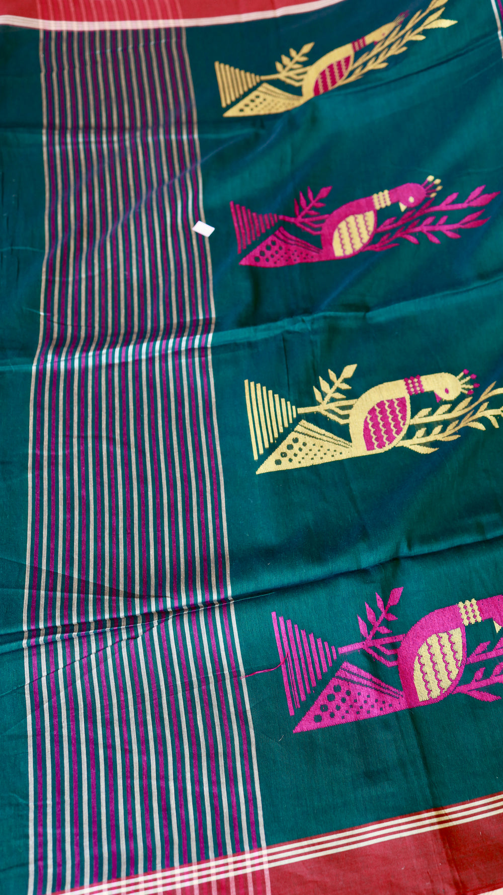 Close-up of the saree pallu (aanchal) section, highlighting the distinctive white and magenta pink vertical striped pattern next to the main green body.