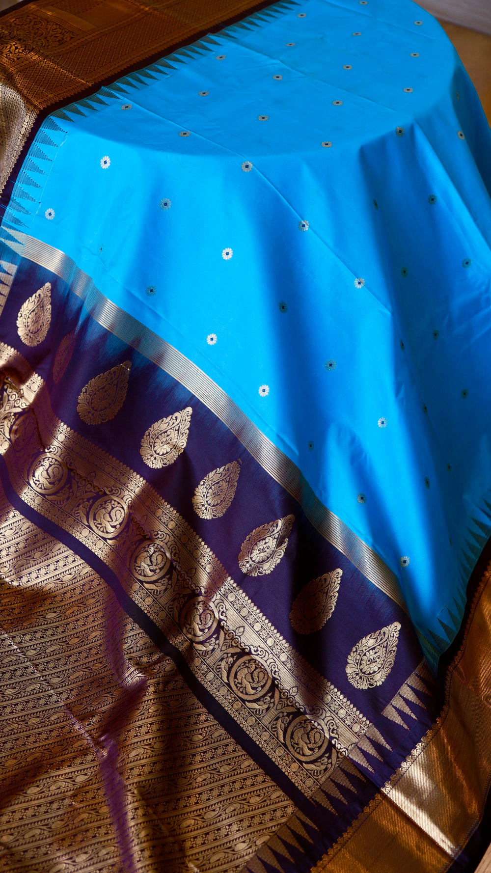 Full drape view of sky blue semi Gadwal saree with gold buttis and contrast purple border