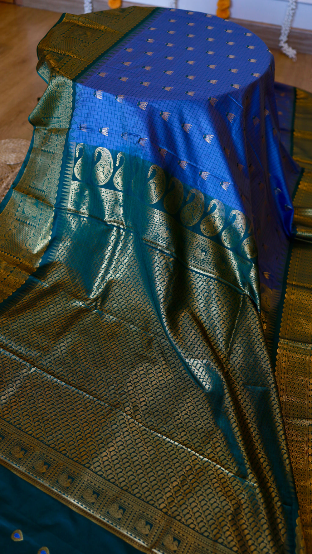 Royal Blue Semi Gadwal Silk Saree with gold floral butis draped over a display showing the peacock green zari border and heavy pallu.