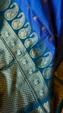 Close-up shot of the woven mango paisley motifs and geometric zari border on the Peacock Green edge of the saree.