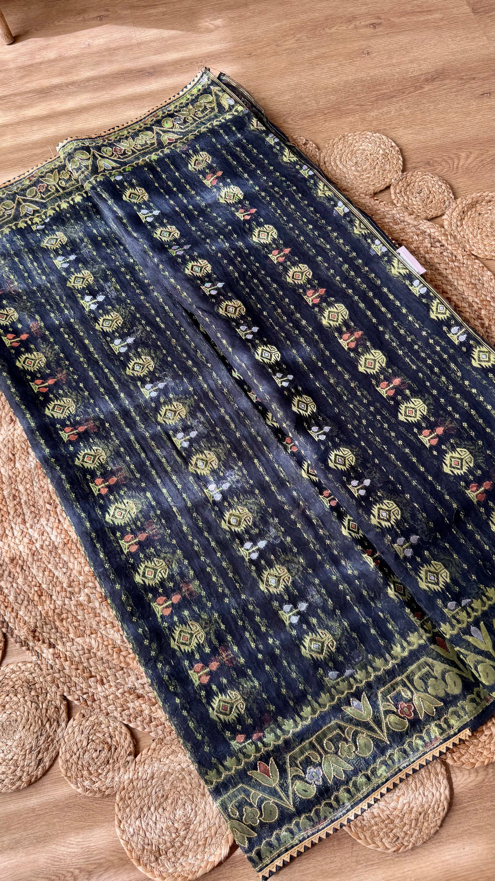 Flat lay of the Black Kardana Jamdani Saree displaying vertical stripe body weave with repeating micro-motifs alongside decorative borders.