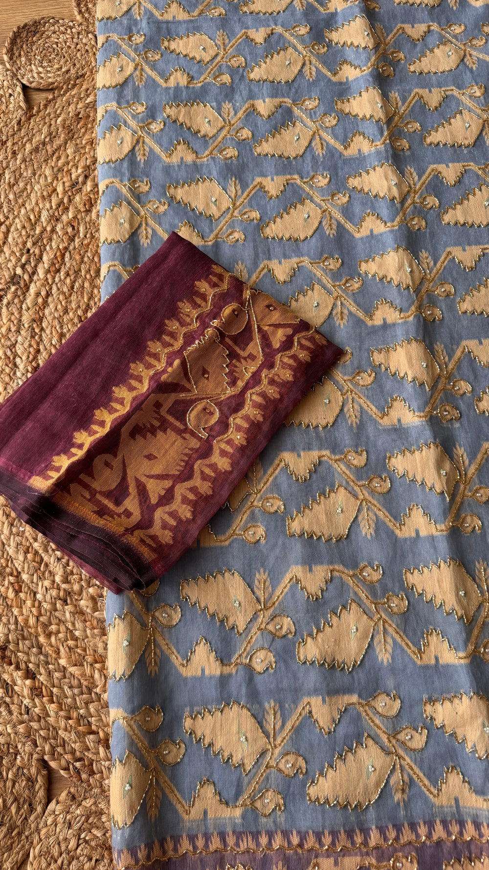 Close-up of powder blue Kardana Jamdani saree fabric paired with contrasting deep plum purple unstitched blouse piece.