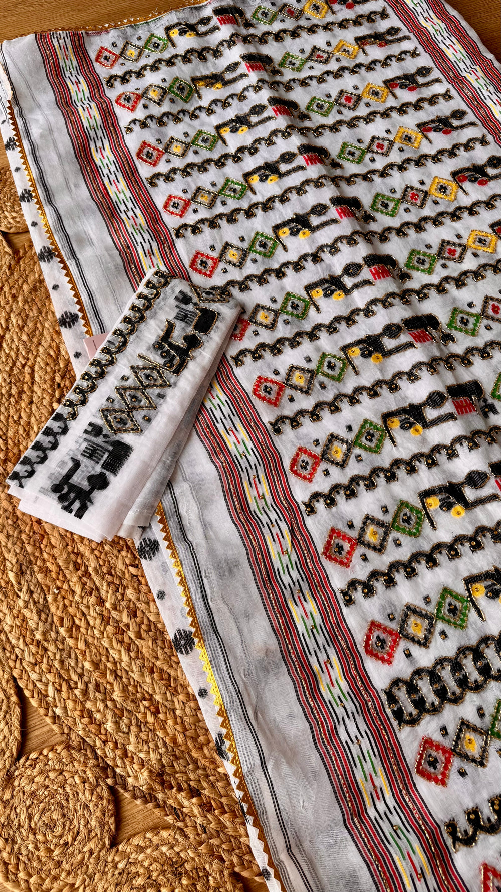 Complete set view of off-white Kardana Jamdani saree laid flat alongside its matching embroidered blouse piece.