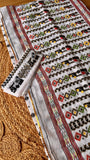 Complete set view of off-white Kardana Jamdani saree laid flat alongside its matching embroidered blouse piece.