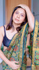 Reel video of Woman draped in a teal Maheshwari Silk Saree with red and green Ajrakh block prints, posing near a wooden door.
